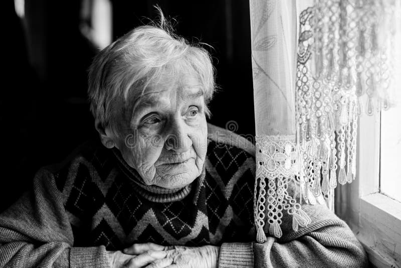 woman looking out window black and white