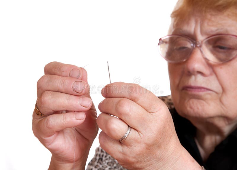 The old woman passes thread in needle