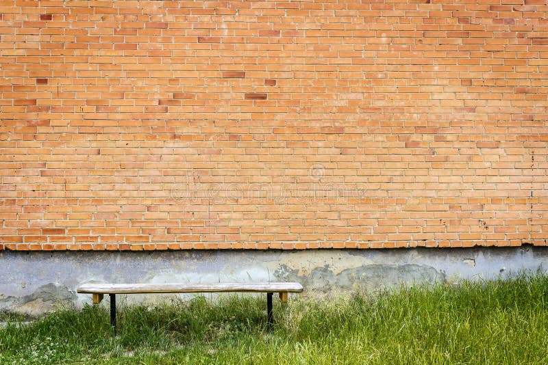 Old wooden bench by red brick wall stock image Old wooden bench by red brick wall stock image