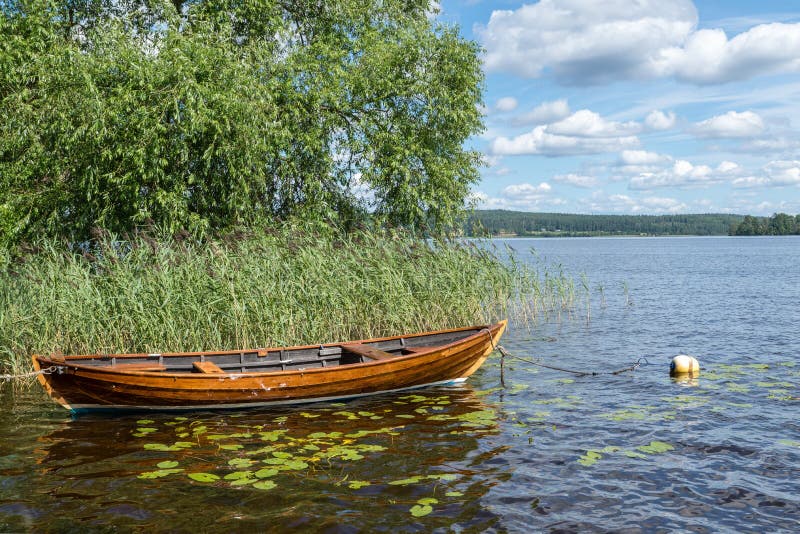 Old wooden boat tied to a buoy on a sunny summer day