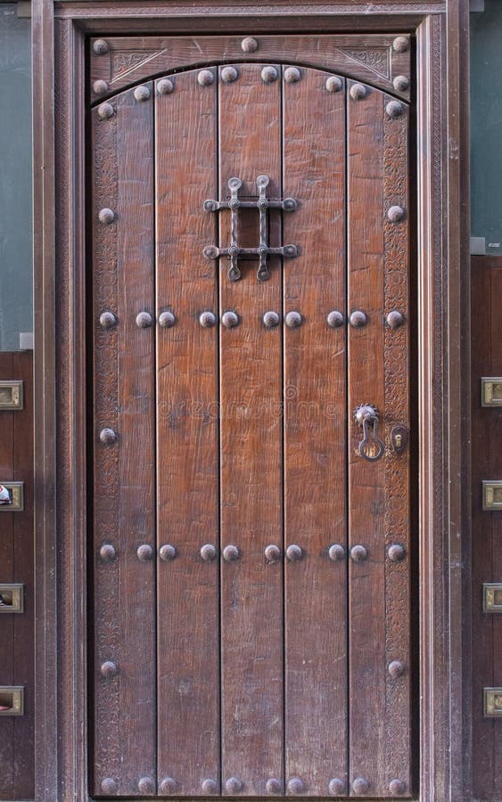 Old wooden door with metal lock. Vintage brown door. Closed doorway of old house. Entrance to antique house.