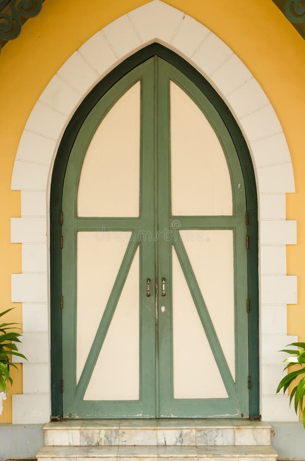 Old wooden door orange wall background with stoned frame