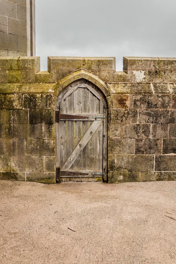 Old wooden door in a stoned wall castle wall