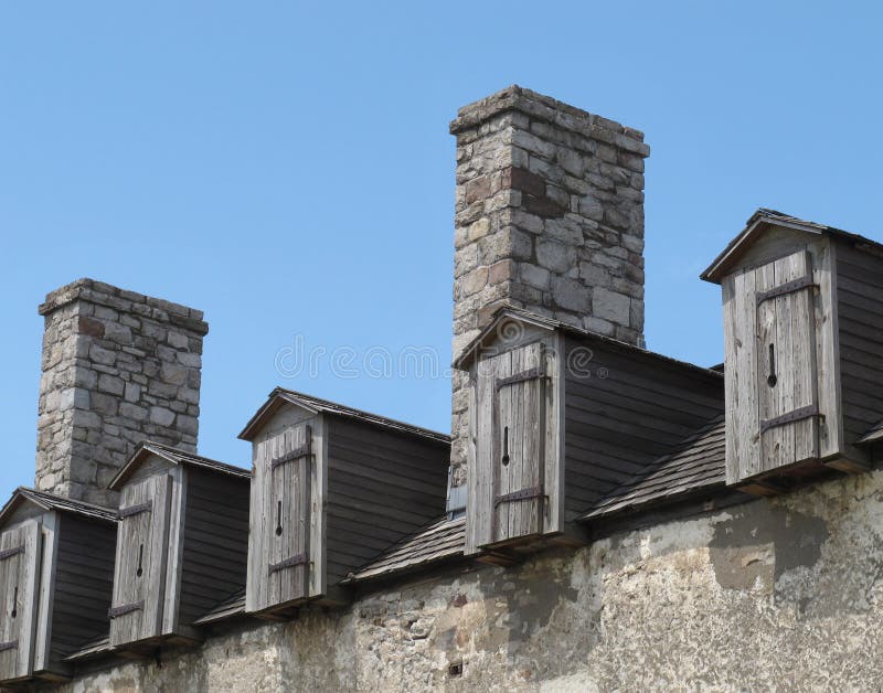 Old wooden dormers on stone building royalty free stock photo