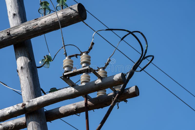 Old wooden high voltage electric transmission tower with wires on insulators