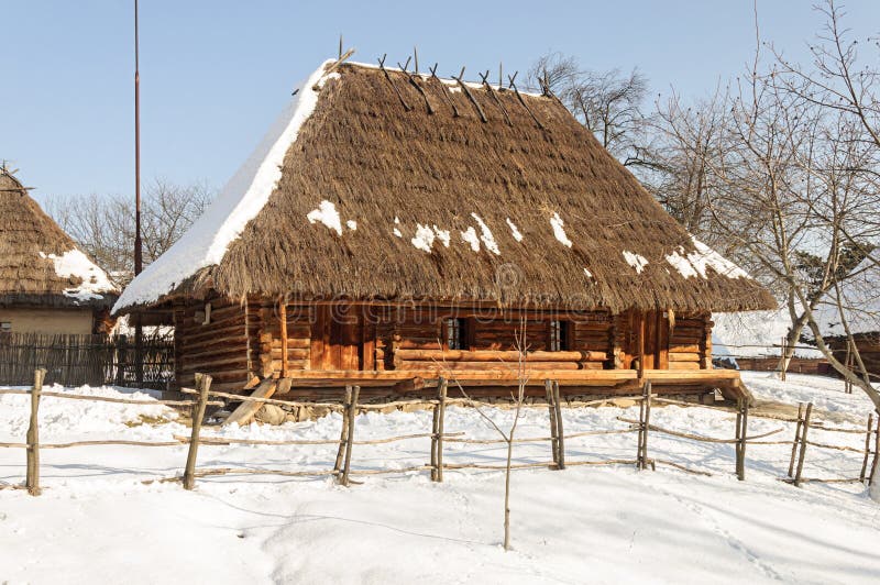 Old wooden peasant`s house with straw roof