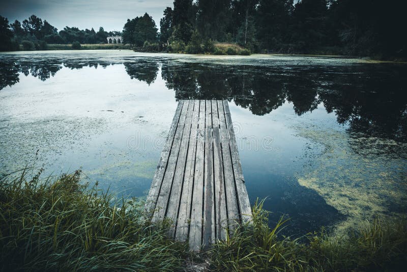 Old wooden pier in lake, Idyllic tranquil view nature background with reflection in water royalty free stock photography Old wooden pier in lake, Idyllic tranquil view nature background with reflection in water royalty free stock photography