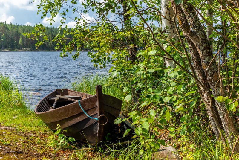 Old wooden rowing boat on the shore of the Saimaa lake in Finland - 1