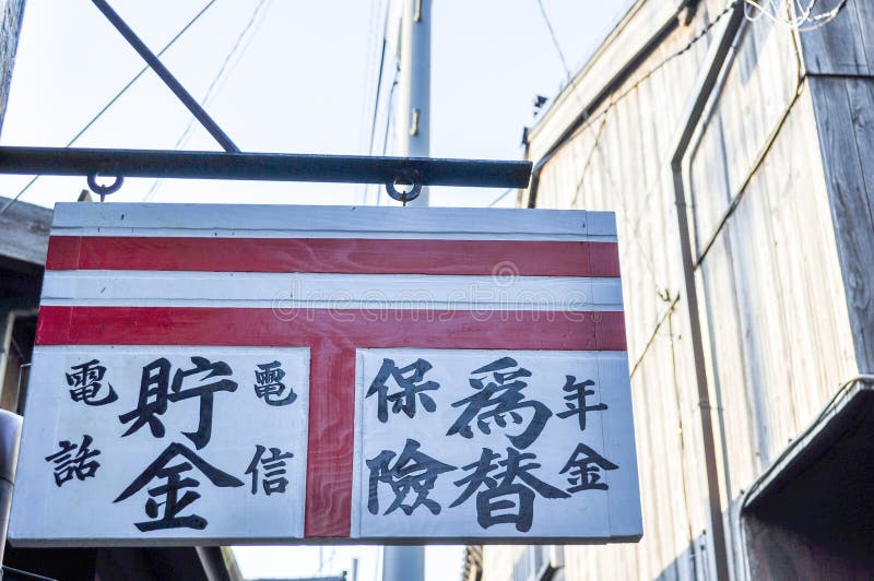 Old wooden sign of a Japanese post office translations from left to right: telephone, savings, telegram, insurance, exchange, pen royalty free stock image Old wooden sign of a Japanese post office translations from left to right: telephone, savings, telegram, insurance, exchange, pen royalty free stock image
