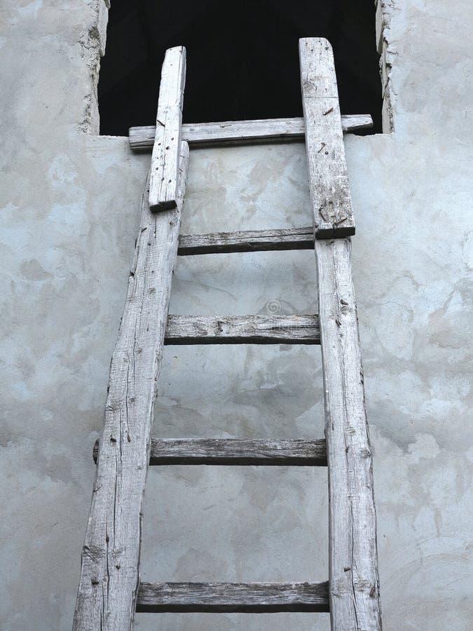 Old wooden vintage cuve ladder near a wall