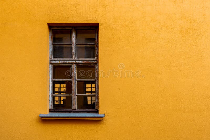 Old yellow house facade with wooden window. Copy space