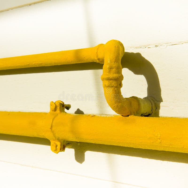 Old Water and Gas Pipes Varnished in Yellow and Fixed with Metal