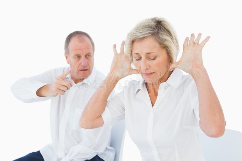 Older couple sitting in chairs arguing