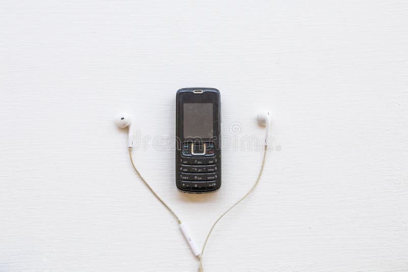 Older Mobile Phone Press the Button Old Generation with Earphone Stock