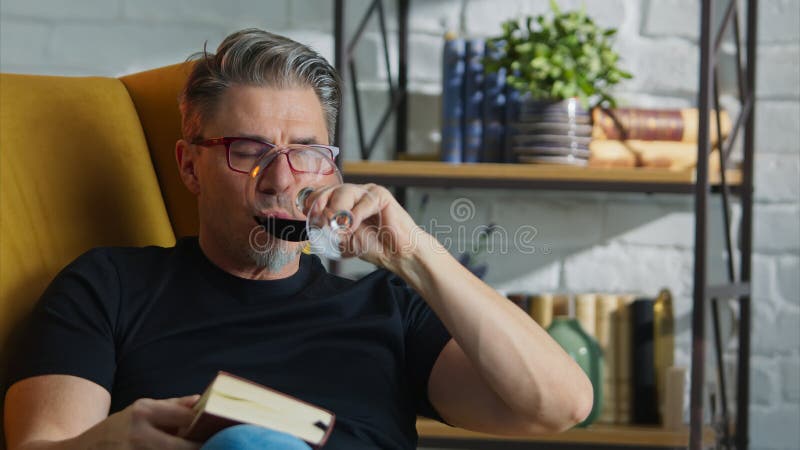 Older white man in glasses reading at home