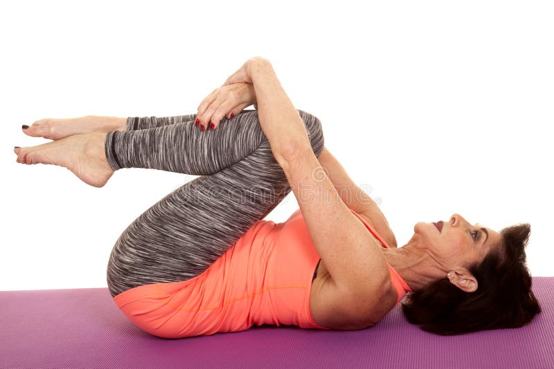 Older woman yoga on back curl knees