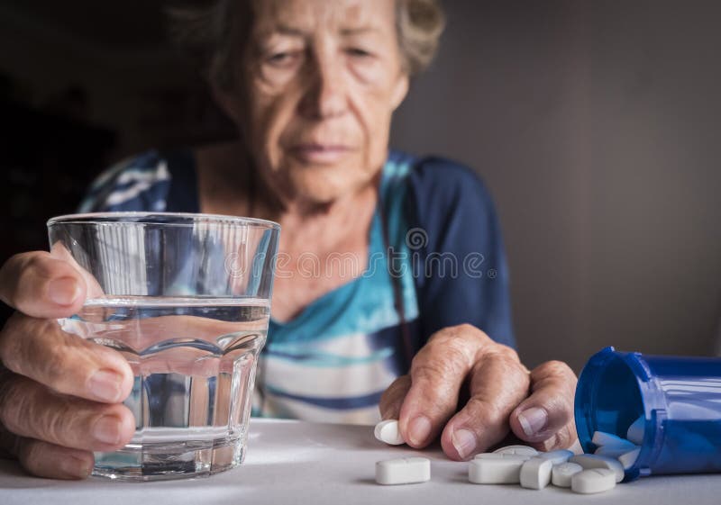 Oldster taking daily medication dose at home