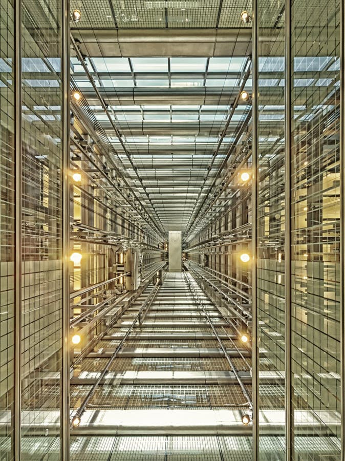 Olhando acima um eixo de elevador em um arranha-céus de vidro moderno Arquitetura, perspectiva imagem de stock Olhando acima um eixo de elevador em um arranha-céus de vidro moderno Arquitetura, perspectiva imagem de stock