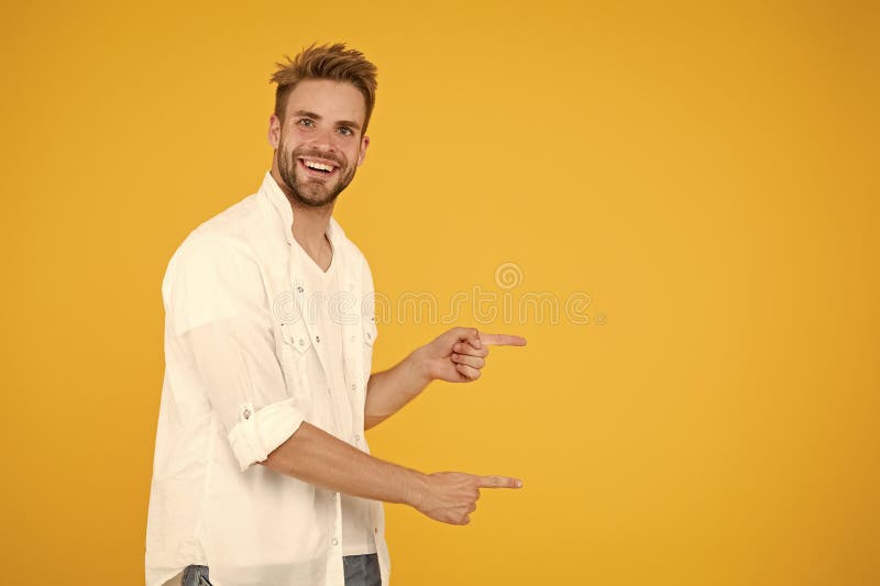 Olhe lá Homem apontando para o espaço de cópia Veja isto Homem muscular bonitão sorridente homem sem barba em fundo amarelo fotos de stock royalty free Olhe lá Homem apontando para o espaço de cópia Veja isto Homem muscular bonitão sorridente homem sem barba em fundo amarelo fotos de stock royalty free