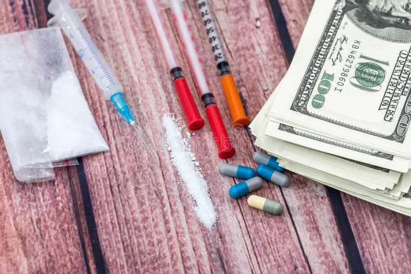 Olik preventivpillerar, kokainpulver, dollarräkningar och injektionsspruta royaltyfri fotografi Olik preventivpillerar, kokainpulver, dollarräkningar och injektionsspruta royaltyfri fotografi