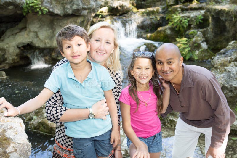 olik stående av en lycklig familj som besöker i parkera arkivfoto olik stående av en lycklig familj som besöker i parkera arkivfoto