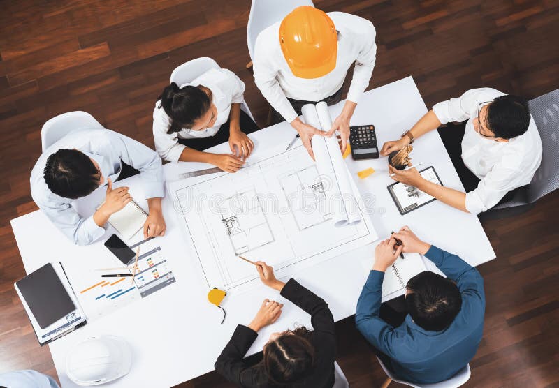 Top view banner of diverse group of civil engineer and client working together on architectural project, reviewing construction plan and building blueprint at meeting table. Prudent. Top view banner of diverse group of civil engineer and client working together on architectural project, reviewing construction plan and building blueprint at meeting table. Prudent