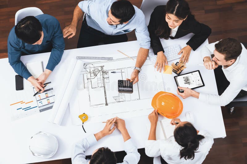 Top view banner of diverse group of civil engineer and client working together on architectural project, reviewing construction plan and building blueprint at meeting table. Prudent. Top view banner of diverse group of civil engineer and client working together on architectural project, reviewing construction plan and building blueprint at meeting table. Prudent