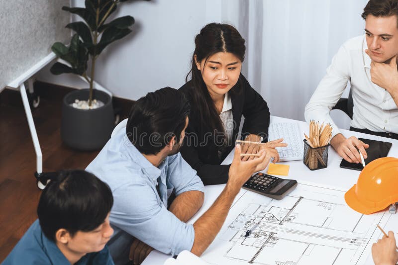 Diverse group of civil engineer and client working together on architectural project, reviewing construction plan and building blueprint at meeting table. Prudent. Diverse group of civil engineer and client working together on architectural project, reviewing construction plan and building blueprint at meeting table. Prudent