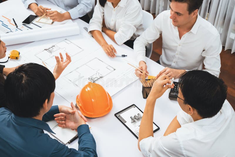 Diverse group of civil engineer and client working together on architectural project, reviewing construction plan and building blueprint using tablet at meeting table. Prudent. Diverse group of civil engineer and client working together on architectural project, reviewing construction plan and building blueprint using tablet at meeting table. Prudent