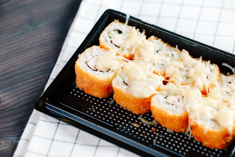 Olika sorter av varma stekte rullar tjänade som i plast- sushiask på tabellen royaltyfria bilder Olika sorter av varma stekte rullar tjänade som i plast- sushiask på tabellen royaltyfria bilder