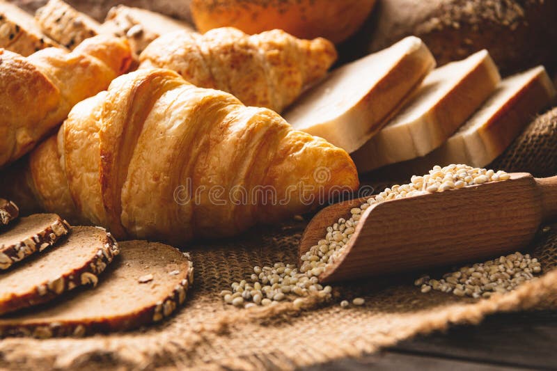 Olika typer av bröd med näringsmässigt hela korn på träbakgrund Livsmedel och bakverk i kökskoncept Frukt