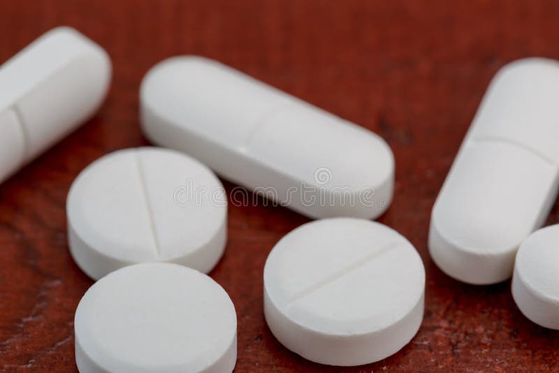 Olika vita preventivpillerar på trätabellen arkivbild Olika vita preventivpillerar på trätabellen arkivbild