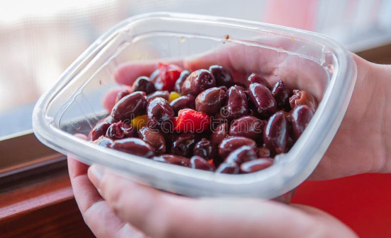 Olive greche porpora di Kalamon o di Kalamata contenute in un vassoio di plastica immagine stock libera da diritti Olive greche porpora di Kalamon o di Kalamata contenute in un vassoio di plastica immagine stock libera da diritti
