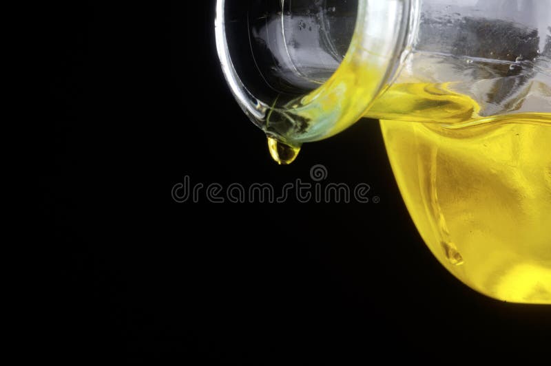Un olio di oliva goccia di versare una bottiglia di vetro.