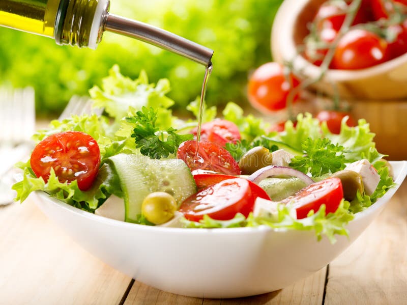 Olive oil pouring over salad