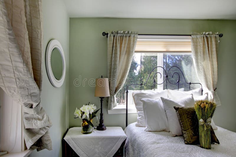 Olive tones bedroom with antique iron frame bed royalty free stock image