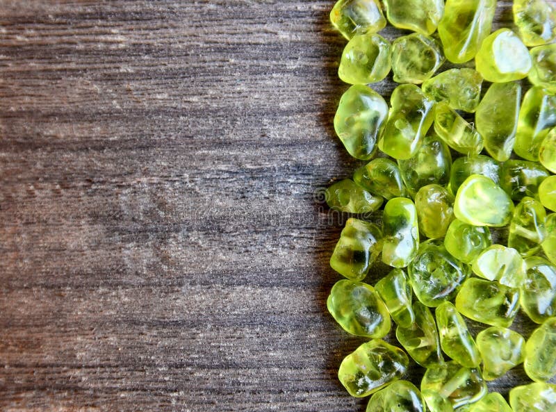 Olivine gemstone also called Peridot on old wooden background.Selective focus.