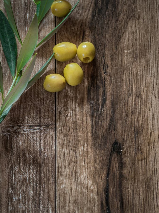 Oliwki peklowane z liśćmi na drewnie z przedziaÅ‚em na kopie fotografia stock Oliwki peklowane z liśćmi na drewnie z przedziaÅ‚em na kopie fotografia stock