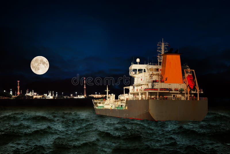 Tanker ship on sea with oil refinery industry in background at night. Tanker ship on sea with oil refinery industry in background at night.