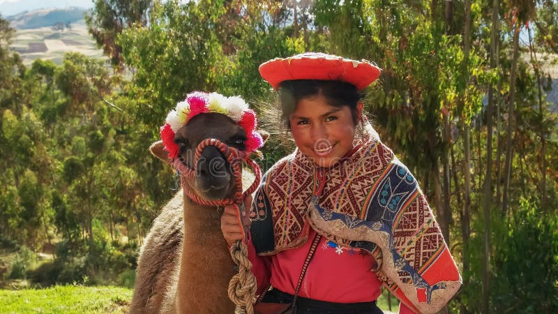 OLLANTAYTAMBO, 17 PERU-MEI, 2016: een Peruviaans meisje stelt met een lama dichtbij ollantaytambo stock foto OLLANTAYTAMBO, 17 PERU-MEI, 2016: een Peruviaans meisje stelt met een lama dichtbij ollantaytambo stock foto