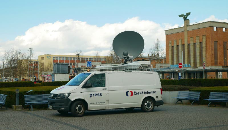 Satellite TV car for live broadcasting to television, modern satellite connection to the transmitter, news antenna warning beacon, technological technology equipment, city street town life, building of the main railway train station Olomouc, Czech Republic, Europe, European Union. Satellite TV car for live broadcasting to television, modern satellite connection to the transmitter, news antenna warning beacon, technological technology equipment, city street town life, building of the main railway train station Olomouc, Czech Republic, Europe, European Union