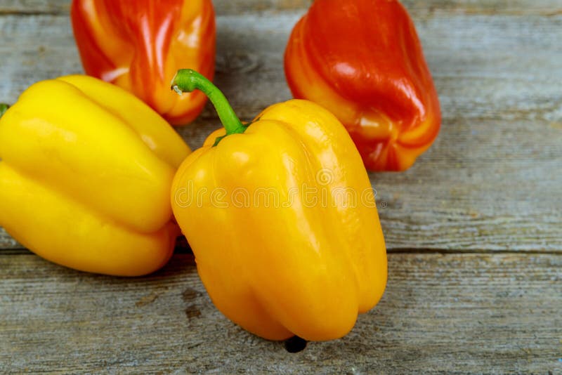 Assorted colorful sweet peppers, wooden table background royalty free stock photography