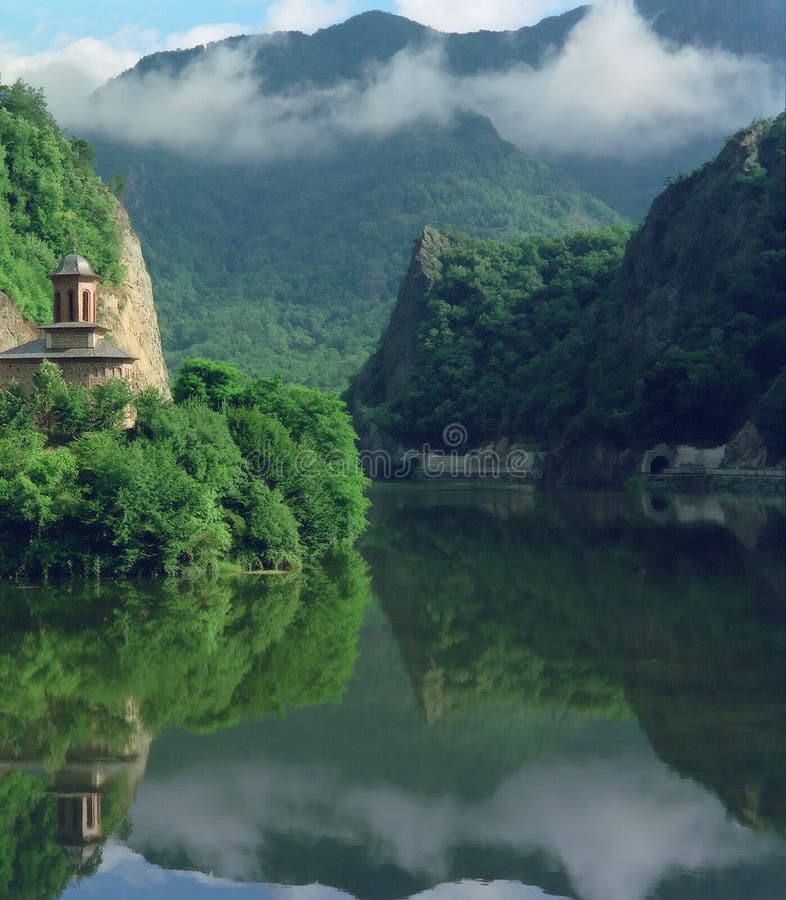 Percorso europeo E81, nascosto qui, sulla riva sinistra, passa un santuario sulla sua strada una mattina nebbiosa Olt gola del fiume al di sotto di Cozia di montagna in Romania.