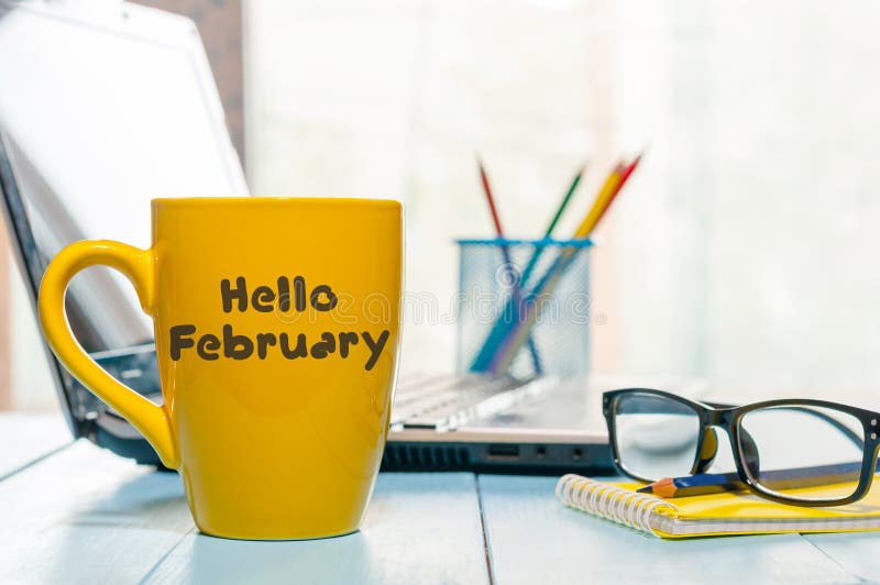 Olá! fevereiro escrito no copo de café amarelo no fundo do escritório para negócios com espaço vazio Tempo de inverno