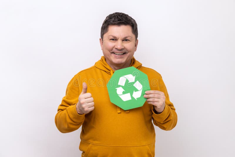 Om care deține un panou de reciclare ecologică și care arată cu degetul cu degetul către camera care solicită sortarea gunoaielor. stock photography
