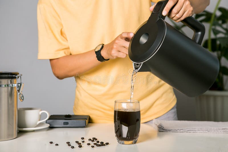 Om care utilizează ceainicul turnând apă caldă, făcând cafea cu gheață sau cafea americană rece în paharul cu unealtă digitală pen stock image