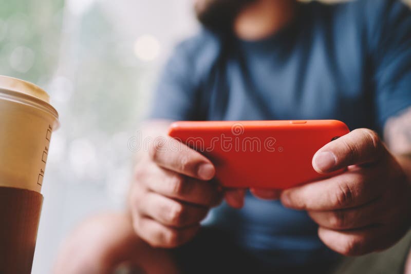 Om cu cafea la pachet folosind smartphone stock image