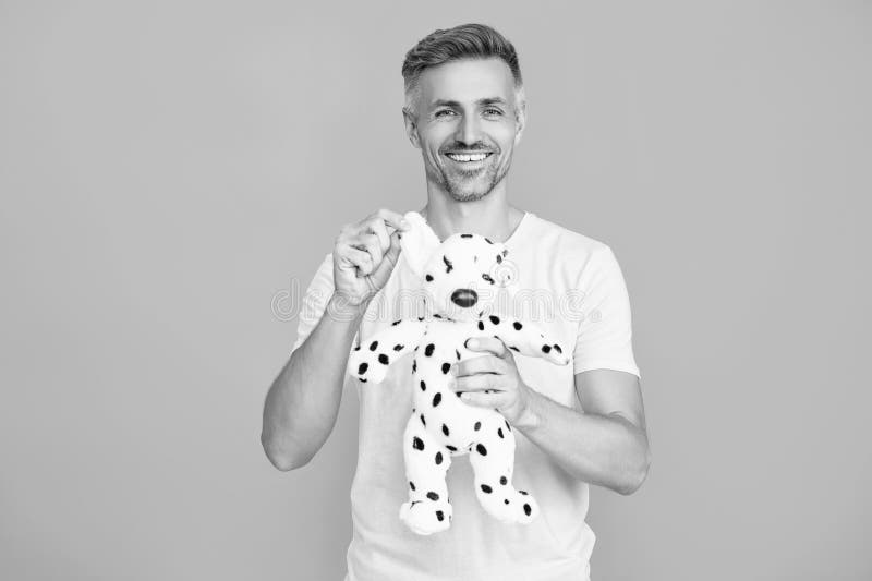 Om cu jucărie izolată pe albastru. Obiceiuri copilărești. Bărbat caucazian care se joacă cu o jucărie. Dispoziție jucăușă. Om opti stock photos