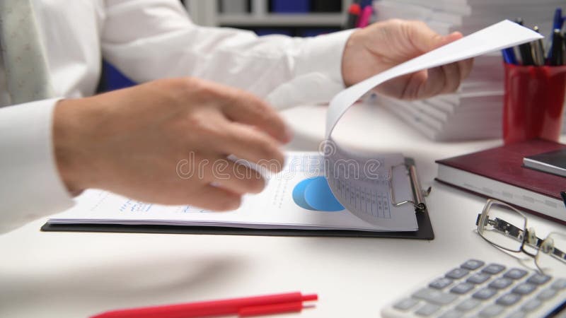 Om de afaceri care lucrează și calculează lecturi și scrie rapoarte. închidere tabel angajat birou. conc pentru contabilitatea fin stock video footage