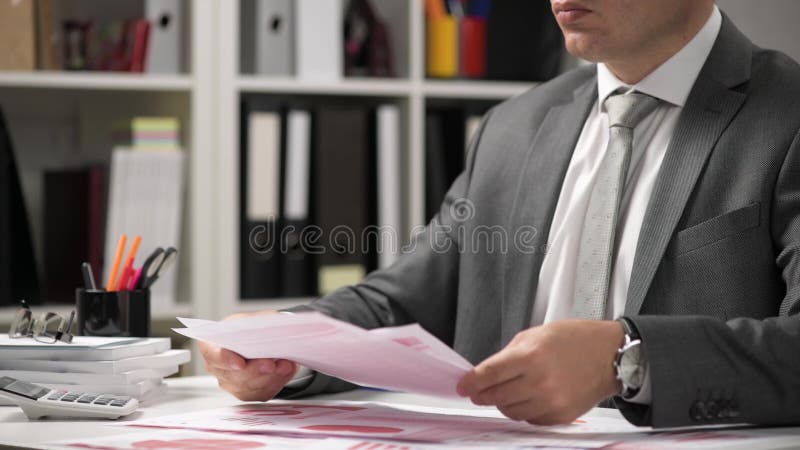 Om de afaceri care lucrează și calculează lecturi și scrie rapoarte. închidere tabel angajat birou. contabilitatea financiară a în stock video